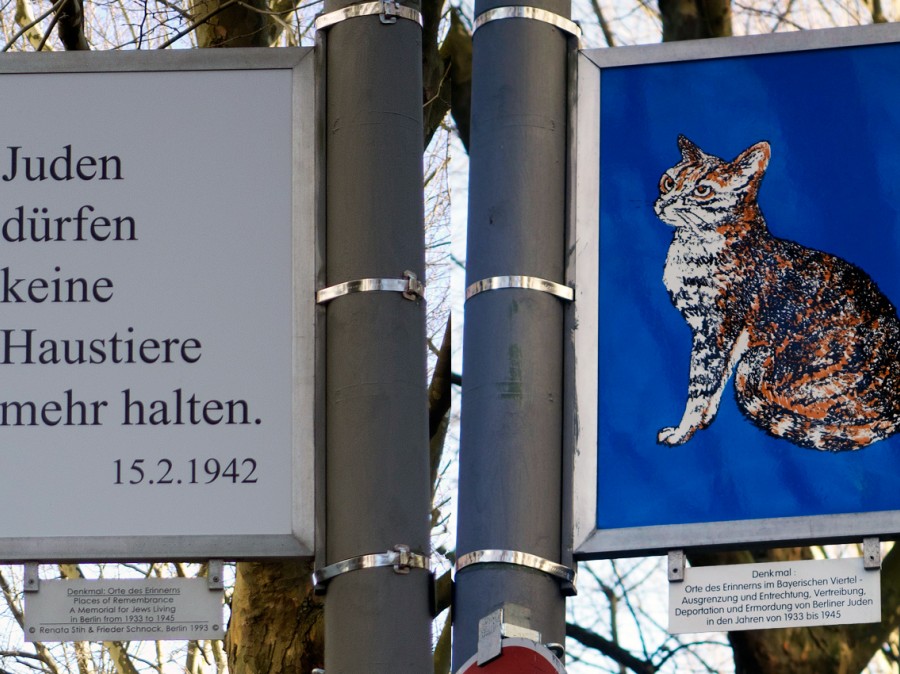 Sign post with sign of 1942 verbage in German along with image of a cat