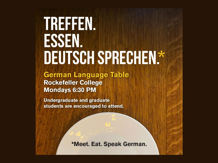 Plate on oak table with text of time, place, to meet, eat, speak German