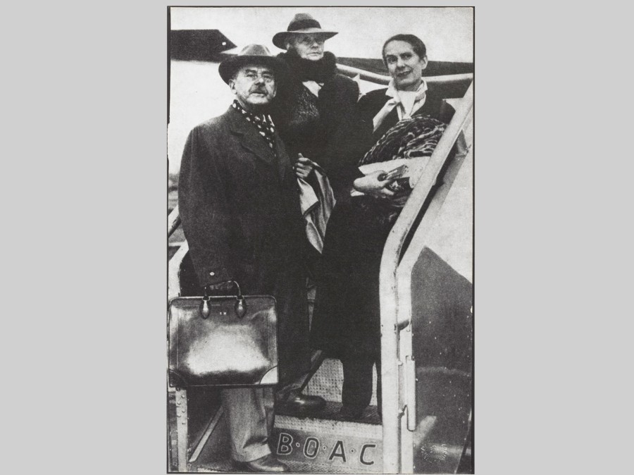 Three people standing in opening of aircraft stairway