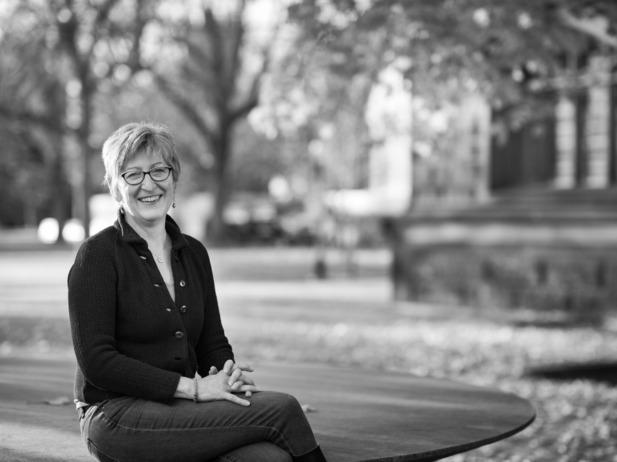 Professor Sally Poor sitting on sculpture outside East Pyne