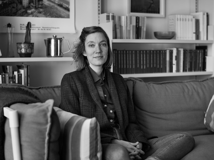 Professor Barbara Nagel sitting on sofa in office with shelves in background.