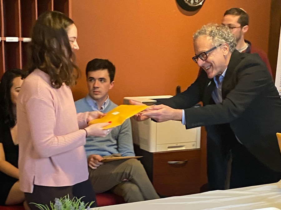 Academic professor handing student her bookprize