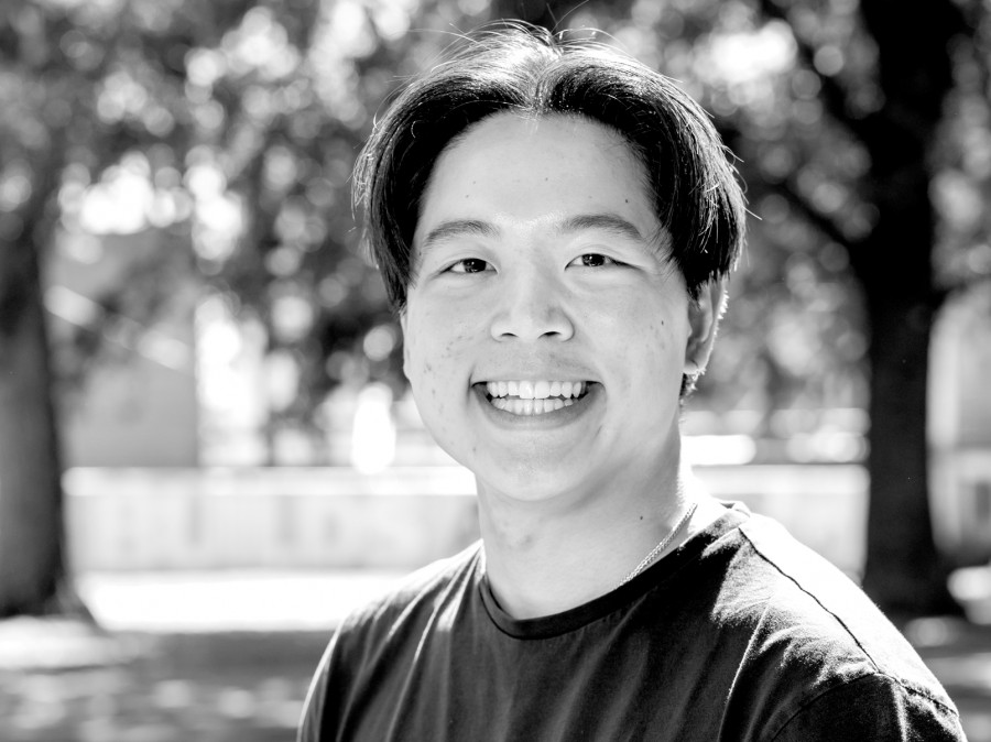 Smiling male student with trees in background