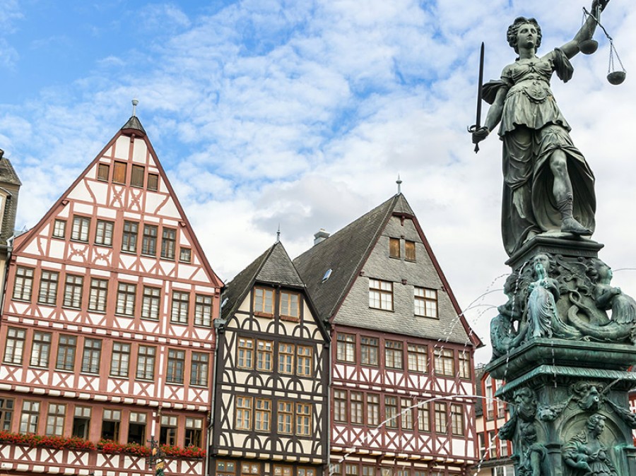 old European architectural shops with fountain statue in foreground