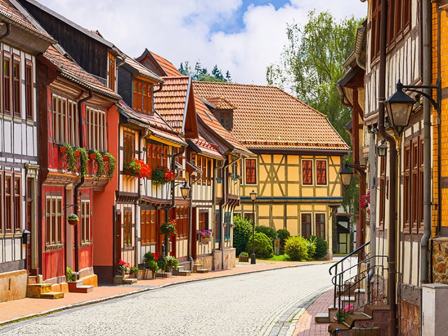 Old European cobblestone street lined with homes and shops during daytime