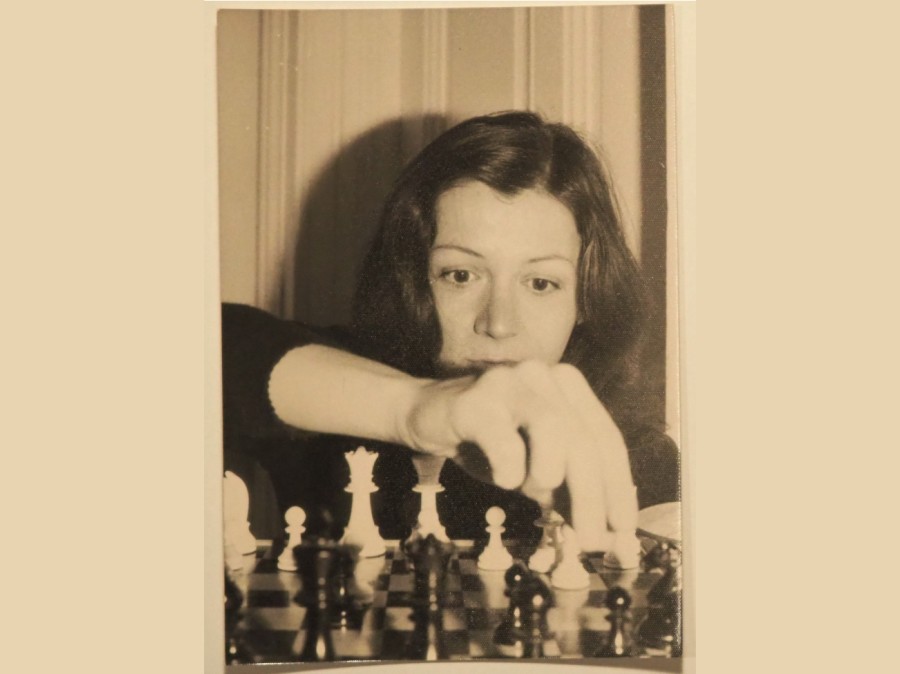 Photo of young woman making chess move