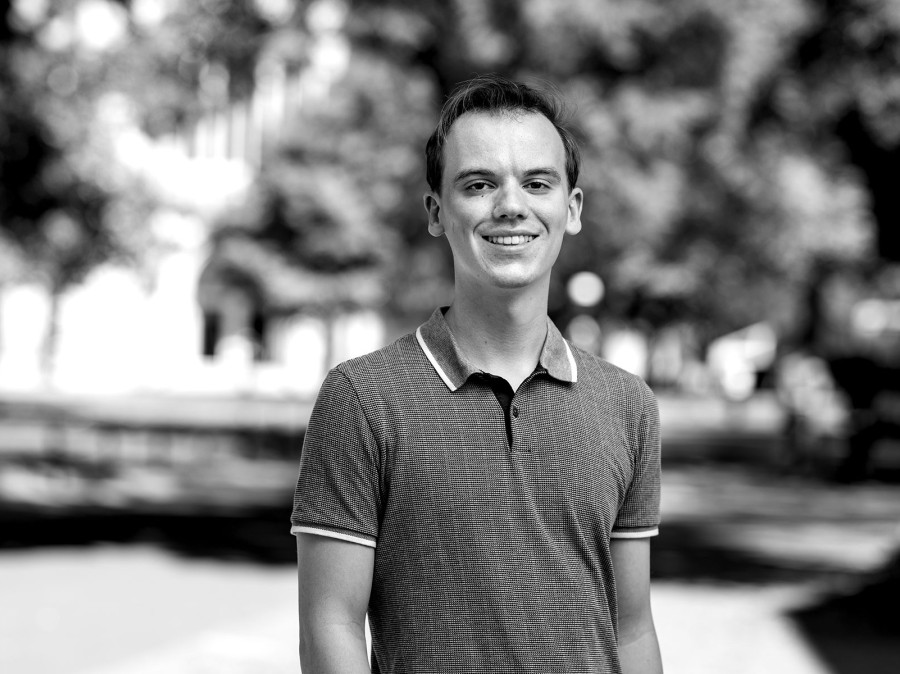 Student in front of campus in background