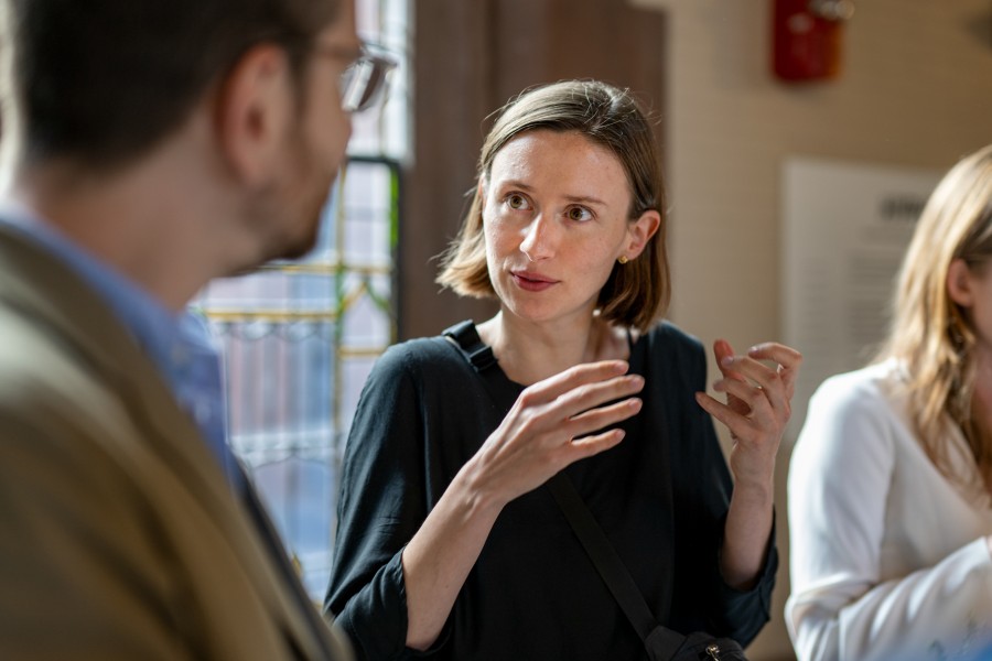 Graduate student in active discussion with another at an event.