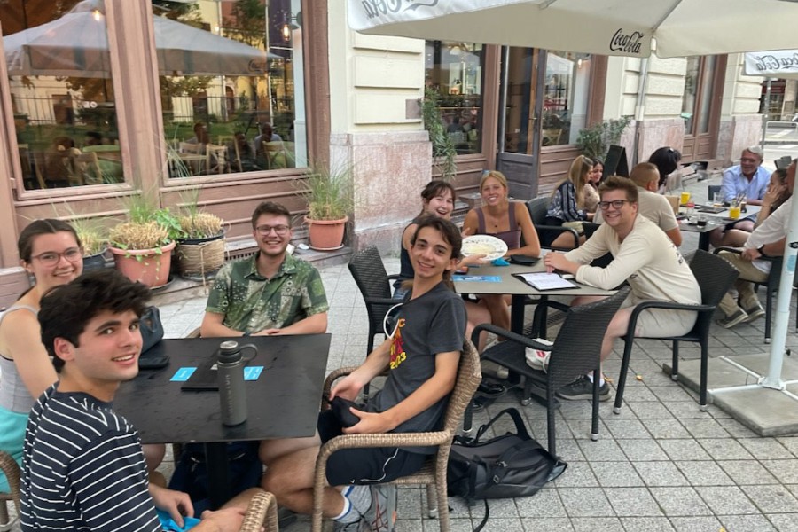 Students smiling in an outdoor cafe setting