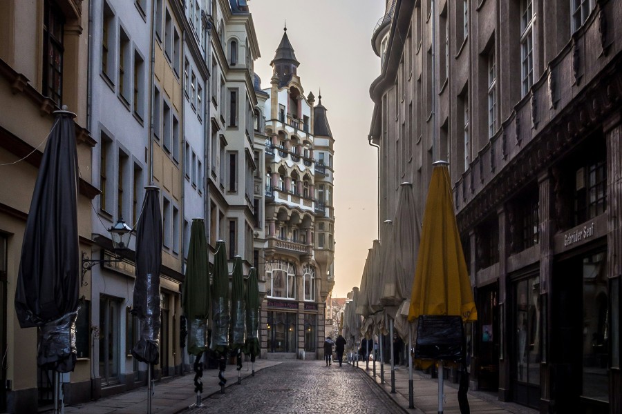 Street view with closed businesses and two people walking further ahead