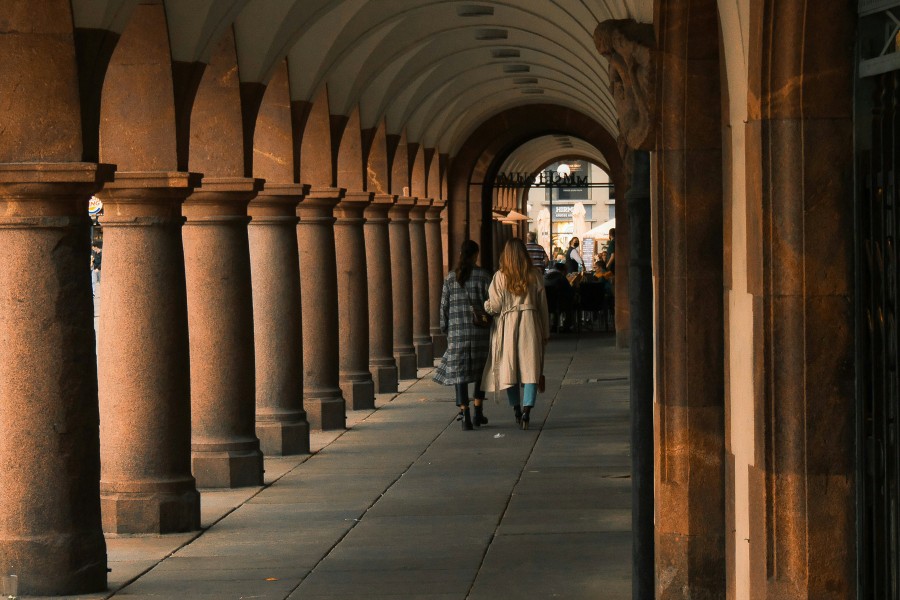 Columns down an exterior walkway with people near end